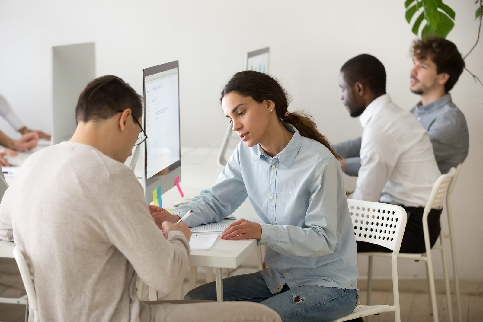 Concentrated Young Female Worker Consulting Male Client, Helping