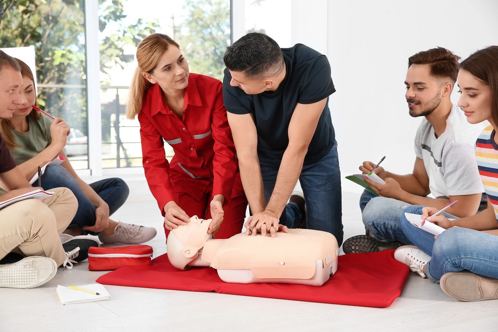 Group Of People With Instructor Practicing Cpr On Mannequin At F