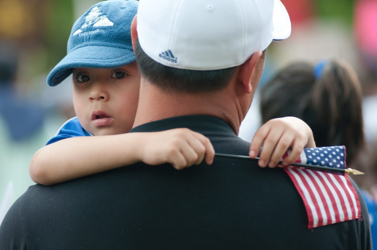 Latino dad and son american flag immigrant intergroup contact cohesive culture research review