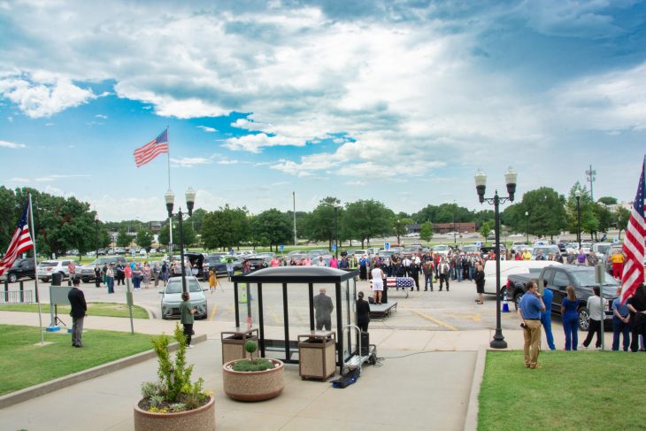 Large crowd gather sin parking lot for final salute for a fallen Veteran.